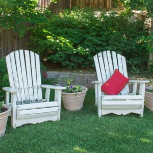 two white chairs and flower pots in the garden